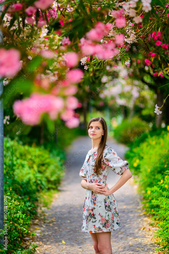 young girl standing near tree with flowers
