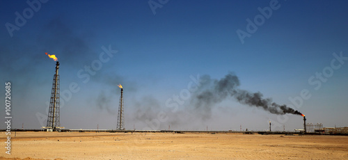 Photography A flare stack burning off excess gas at an oil refinery in the desert of the Mid