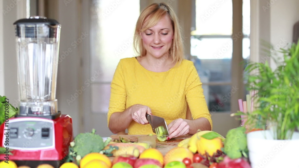 Girl slicing kiwi for smoothie Girl slicing kiwi for smoothie