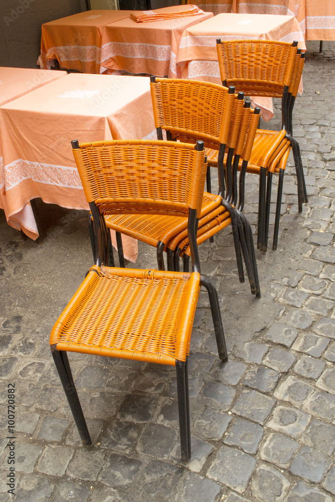 Sedie arancioni accatastate fuoti da un locale rustico di Roma Sedie arancioni accatastate fuoti da un locale rustico di Roma