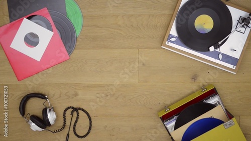 A retro vinlyl record player backtround theme with LP records singles headphones turn table and sleeves for the audio enthusiast. Loopable clip