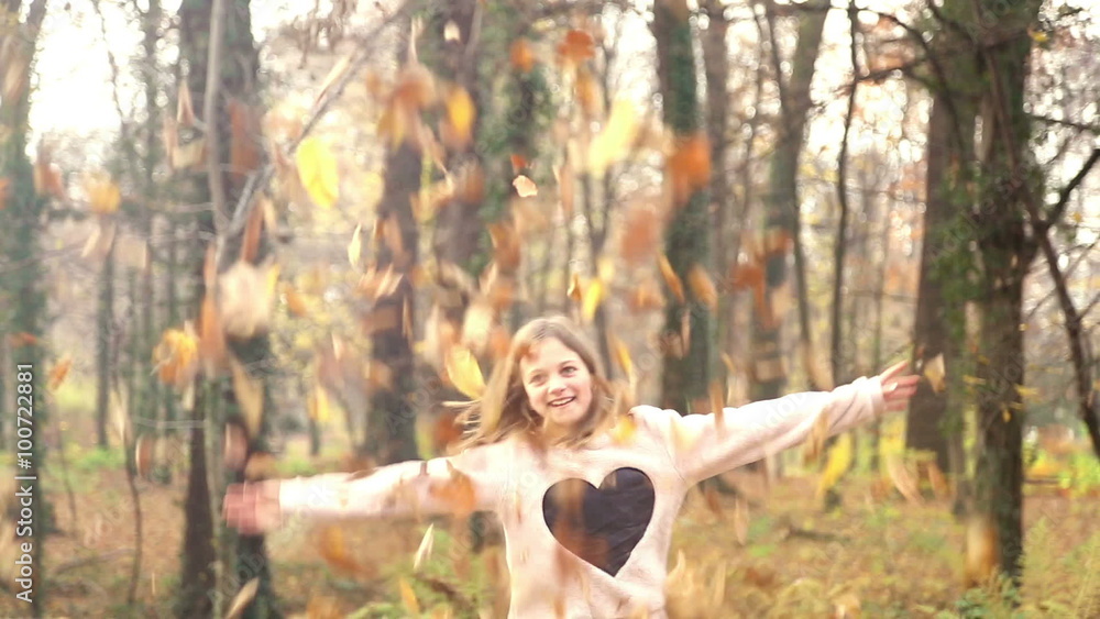 Happy girl having fun throwing leaves in the air Happy girl having fun throwing leaves in the air