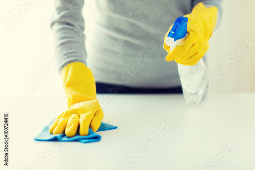 close up of woman cleaning table with cloth