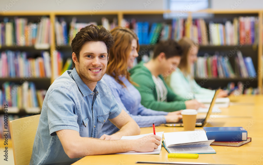 happy student boy with books writing in library happy student boy with books writing in library