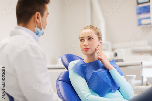 male dentist with woman patient at clinic