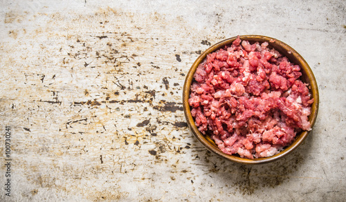 Fresh raw minced meat in a wooden bowl.