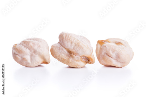 Three align raw dry chickpeas on white background