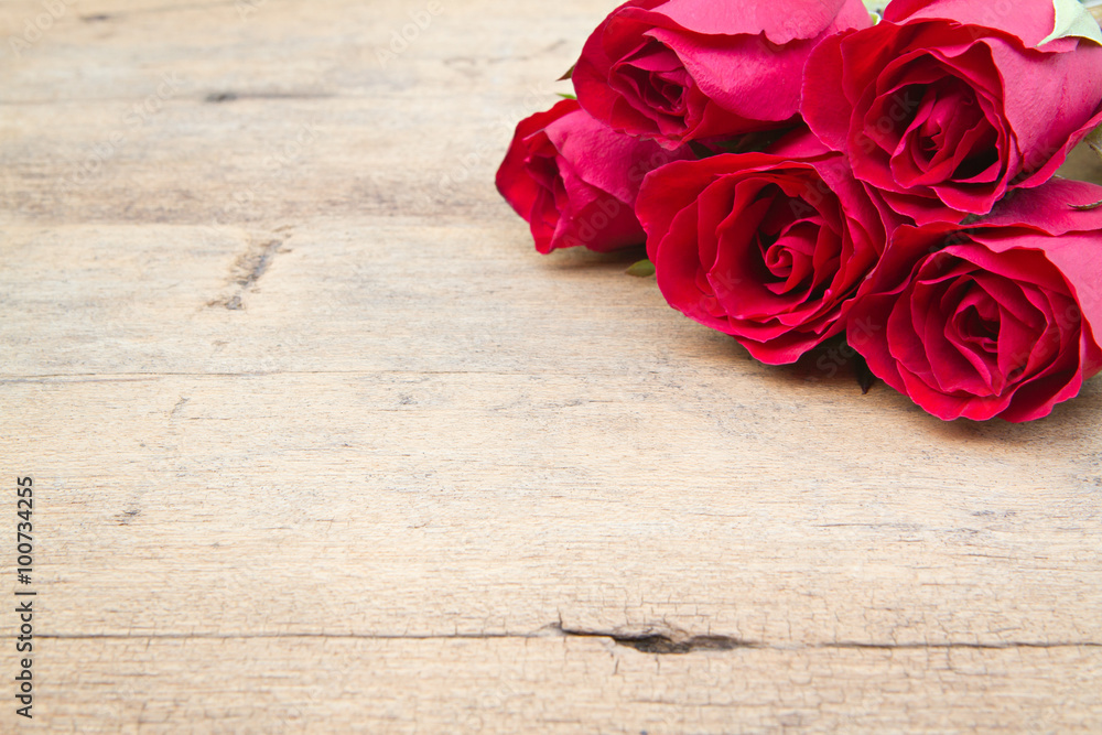 Red roses on woonden background. Valentine's day background.