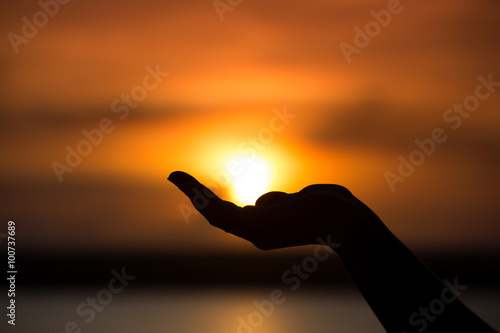 Sun on female hand. Silhouette of hand holding sun  