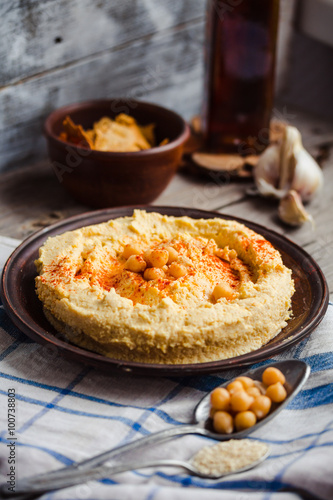 Hummus, chickpea dip, with smoked paprika in a clay plate