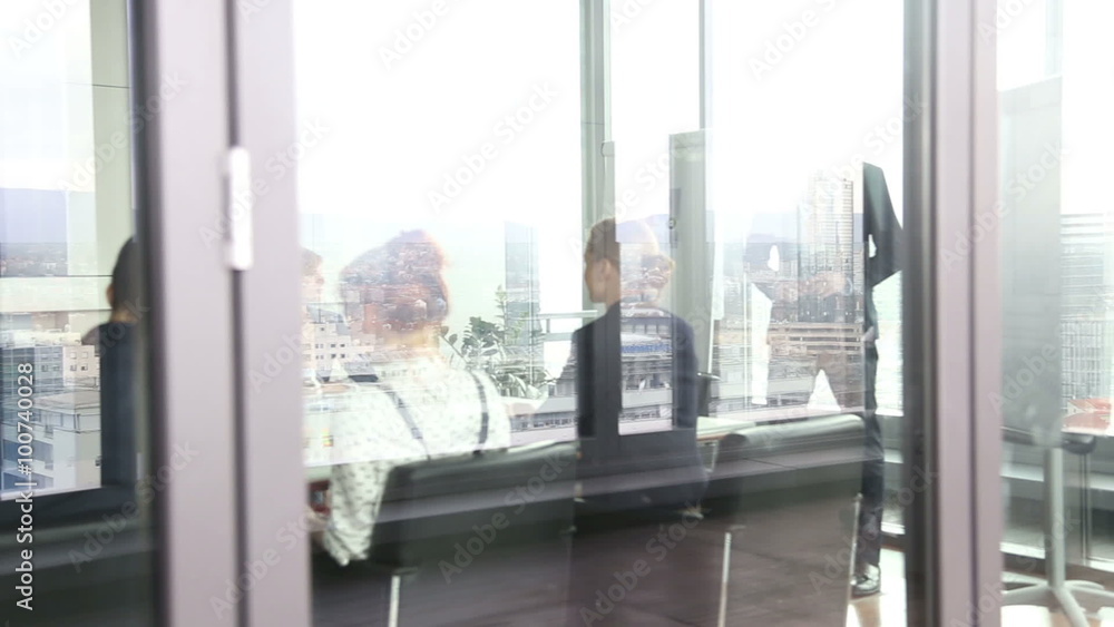 Business people on a meeting behind glass wall Business people on a meeting behind glass wall