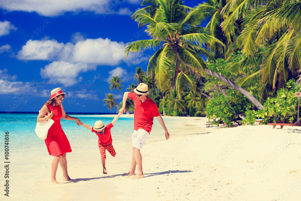 family with kid playing on tropical beach