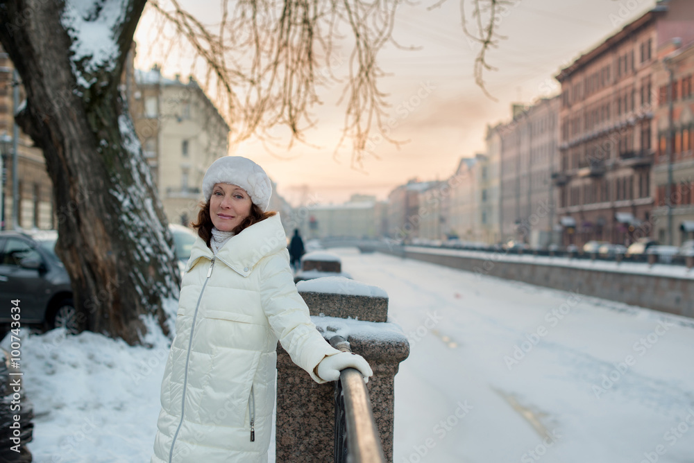 Beautiful woman 50 years old walking on the snowy city of St. Petersburg