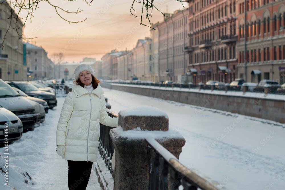 Beautiful woman 50 years old walking on the snowy city of St. Petersburg
