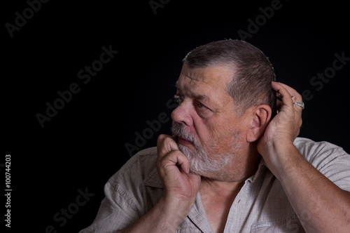 Portrait of senior man desperately thinking about life problems in the darkness