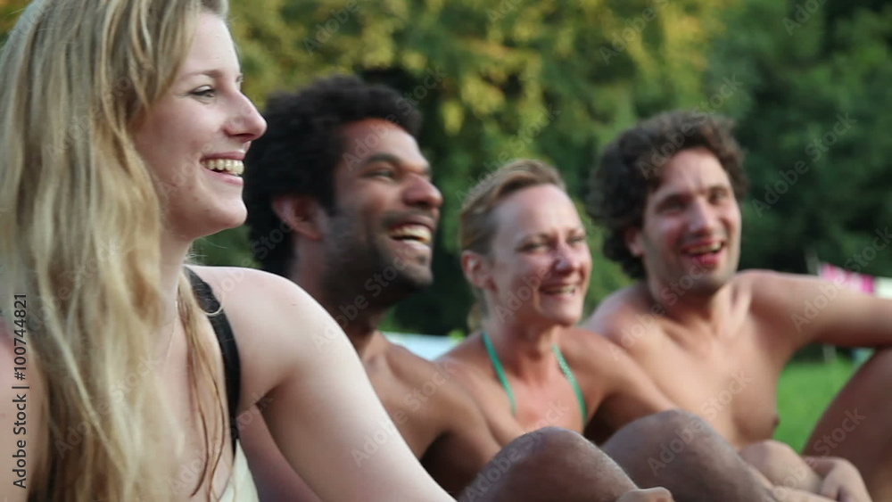 Four friends laughing while sitting in nature Four friends laughing while sitting in nature