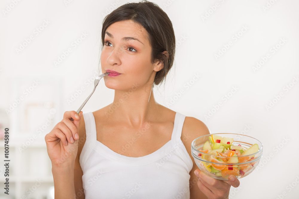 Portrait of a beautiful girl eating a healthy fruit salad Portrait of a beautiful girl eating a healthy fruit salad