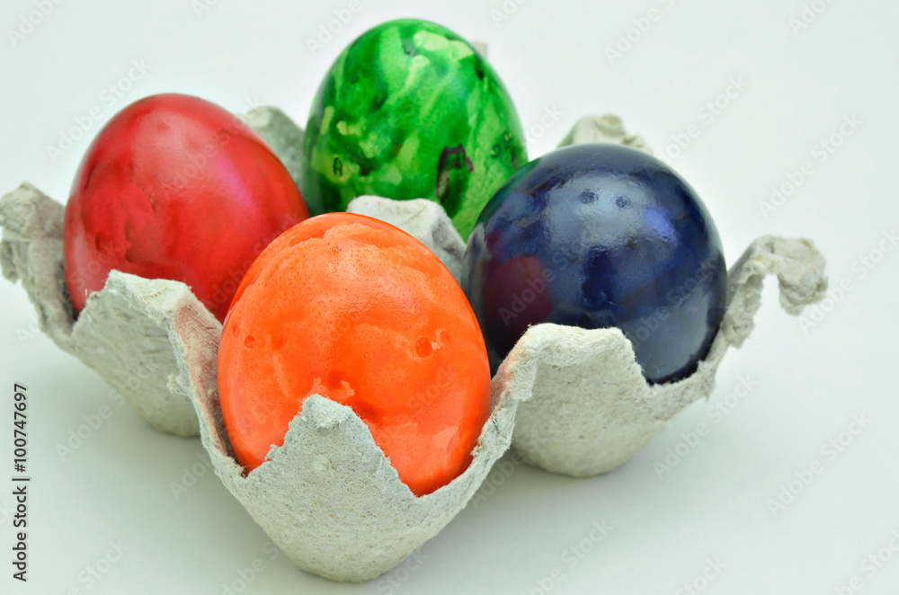 Bunte Ostereier / bunte Ostereier in einem Eierkarton, Nahaufnahme, Makro, isoliert, weißer Hintergrund, Querformat, horizontal

