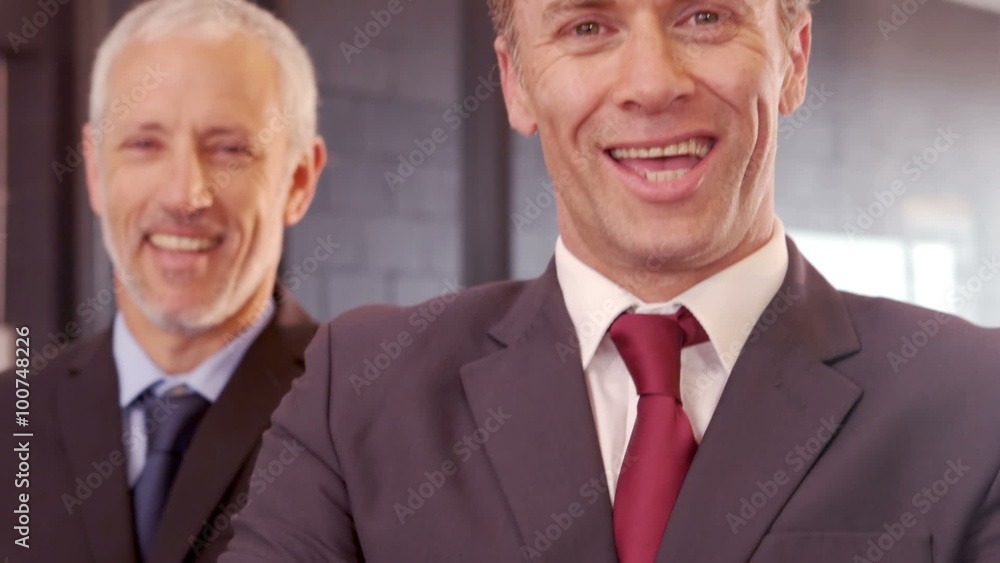 Smiling businessmen posing with crossed arms Smiling businessmen posing with crossed arms