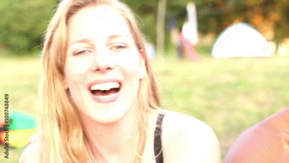 Portrait of group of friends sitting in nature, laughing at camera Portrait of group of friends sitting in nature, laughing at camera