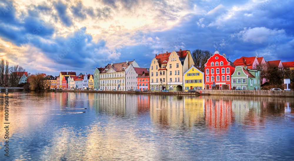Naklejka premium Kolorowe domy gotyckie odbijające się w rzece Isar o zachodzie słońca, Landshut, Niemcy