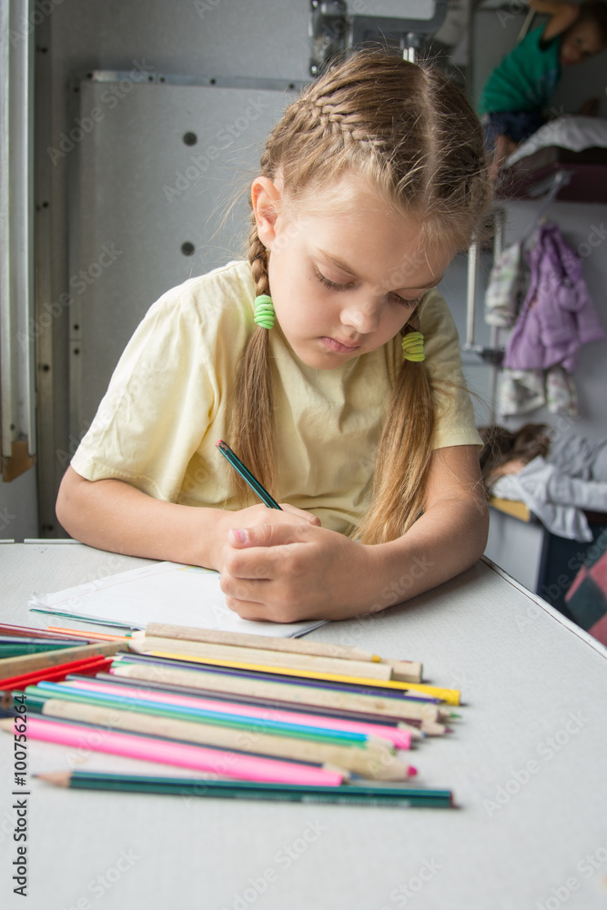 Six year old girl with enthusiasm draws pencils in second-class train carriage Six year old girl with enthusiasm draws pencils in second-class train carriage
