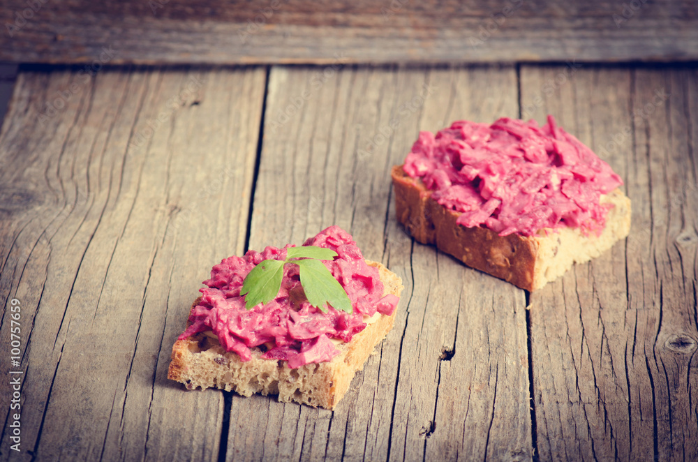 Two slices of bread on a wooden table with beetroot spread. Natural background and healthy, vegetarian and vegan food. Fast breakfast. Raw food. Agriculture Two slices of bread on a wooden table with beetroot spread. Natural background and healthy, vegetarian and vegan food. Fast breakfast. Raw food. Agriculture