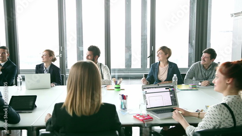 Business people sitting at table in conference room and listening presentation