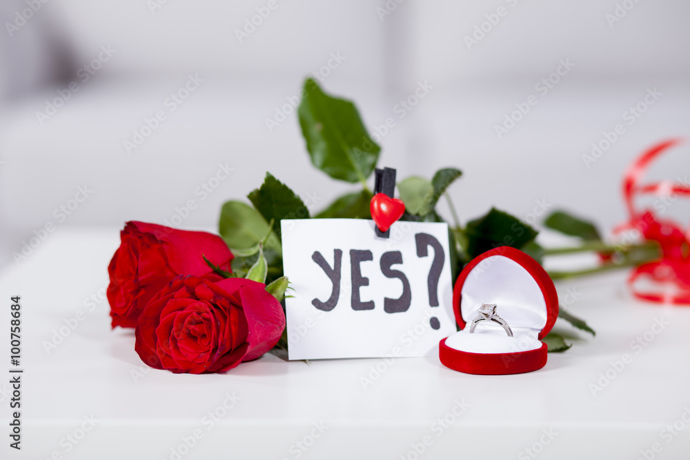 Fototapeta premium Red roses on the table with proposal note yes
