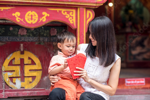 Asian mother give a red envelope or Ang-pow  to son