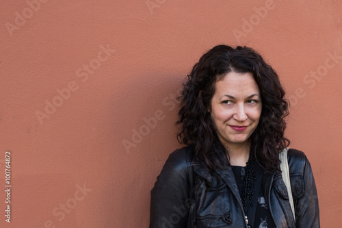 Woman with meaningful look and terra cotta wall