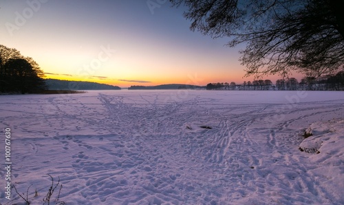 Fototapeta Naklejka Na Ścianę i Meble -  Sunset sky over frozen and snowy lake.