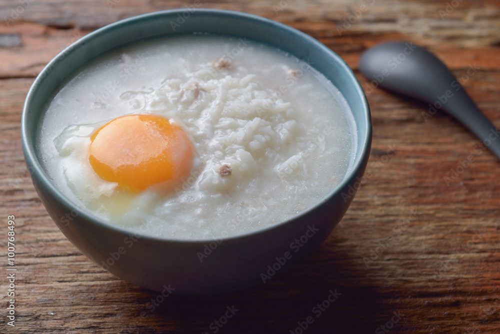 Thai chinese asian rice porridge with pork and egg in bowl, co Thai chinese asian rice porridge with pork and egg in bowl, co