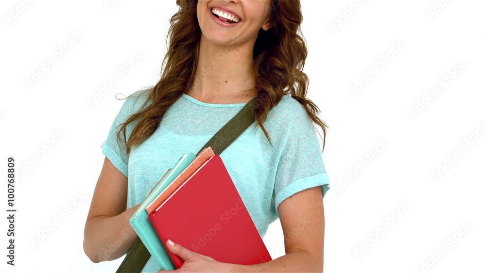 Smiling woman with shoulder bag holding books Smiling woman with shoulder bag holding books