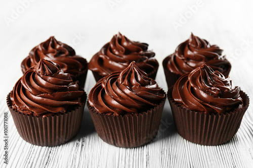 Chocolate cupcakes on light wooden background