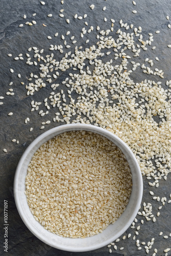 sesame seeds in bowl on rock background