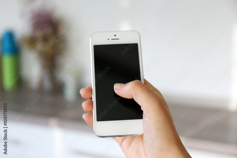 Woman holding smartphone indoors Woman holding smartphone indoors