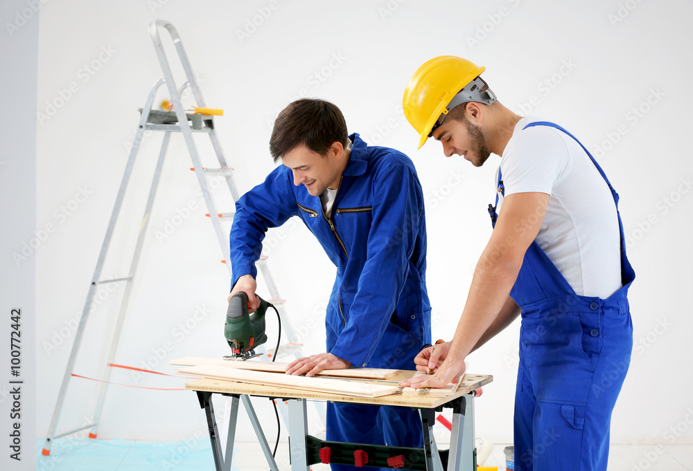 Workers renewing apartment on wall background Workers renewing apartment on wall background