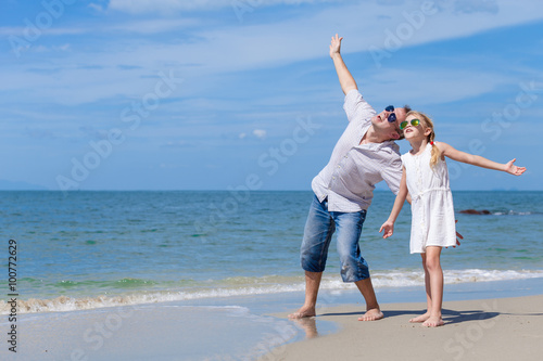 Father and daughter playing on the beach at the day time.