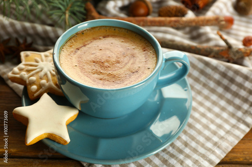 Cup of coffee with star shaped biscuits and Christmas tree branch on napkin