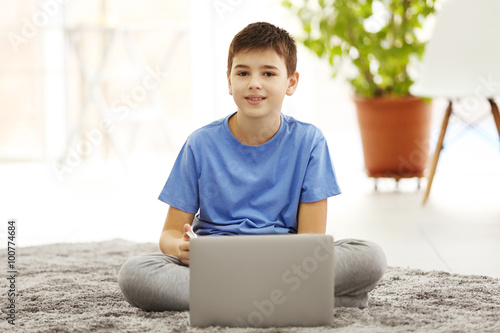 Boy with laptop sitting on ...