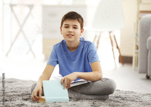 Boy with books lying on a f...