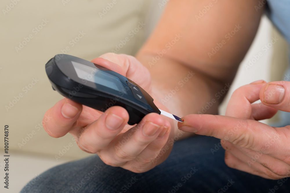 Man Checking Blood Sugar With Glucose Meter Man Checking Blood Sugar With Glucose Meter