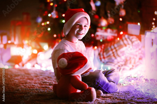 Little boy in Santa hat sit...