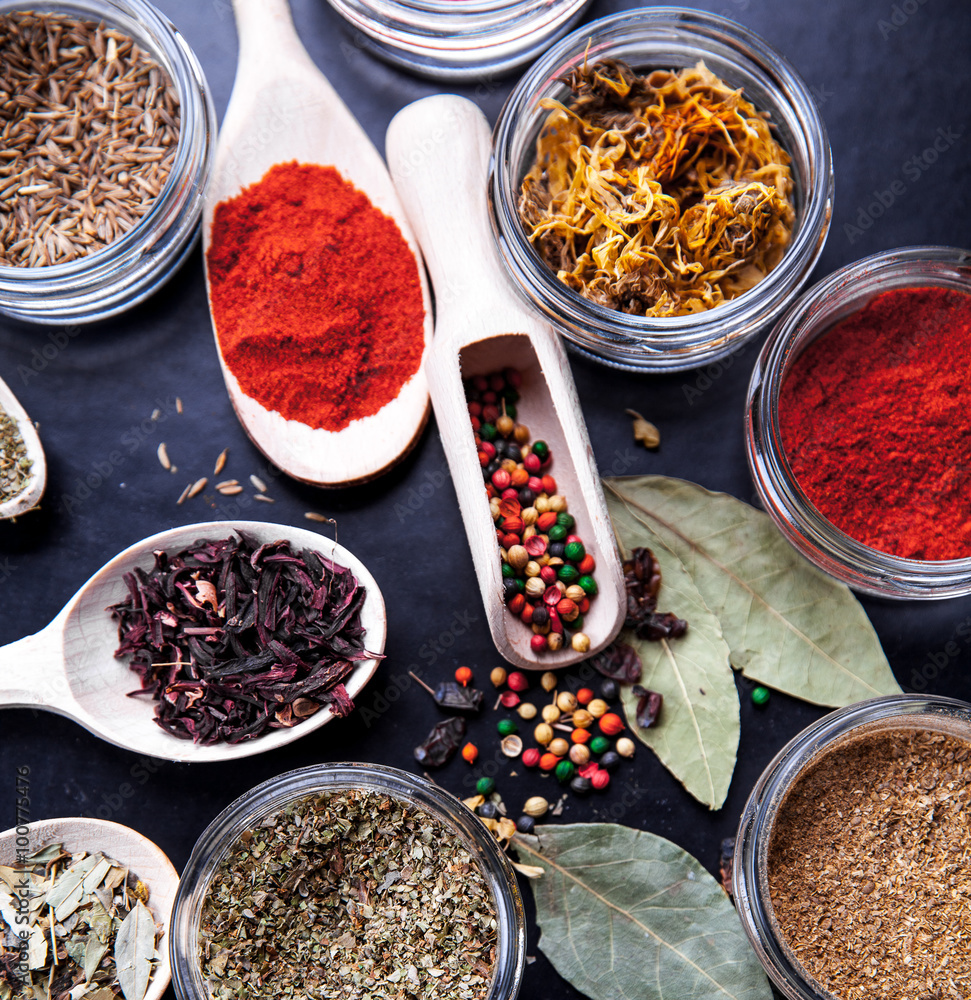 Fototapeta premium Spices on black background in special jars. Food
