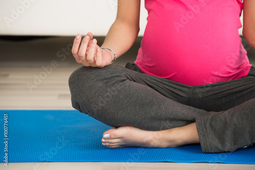 Pregnant Woman Doing Yoga On Exercise Mat At Home