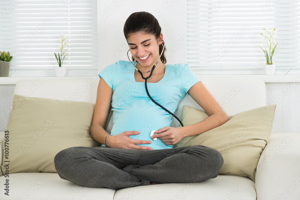 Portrait Of Pregnant Woman Listening To Baby Heartbeat