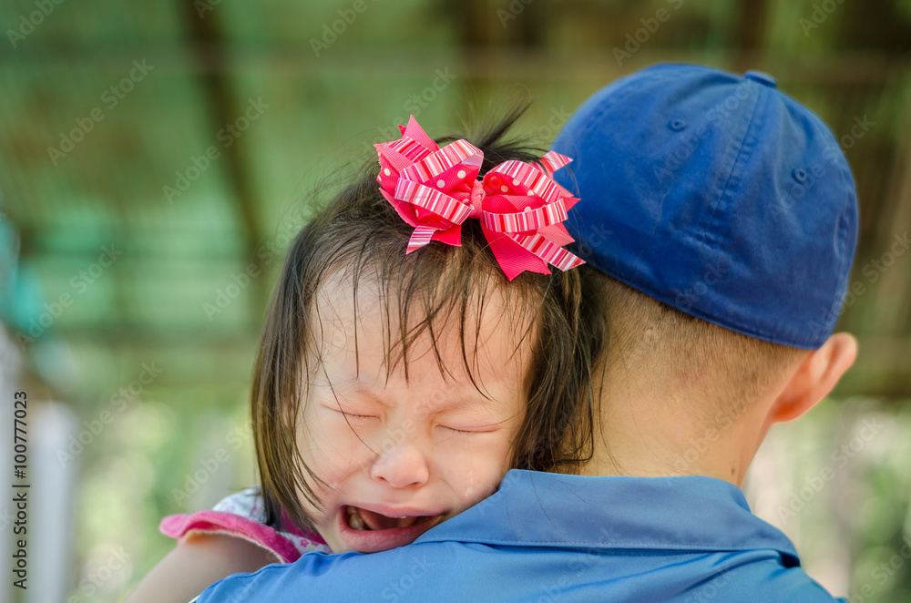 Little Asian girl crying on her father shoulder Little Asian girl crying on her father shoulder