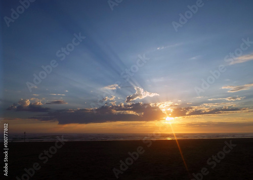 Cloudy Sunset Over the Ocean with Sunbeams in the Sky