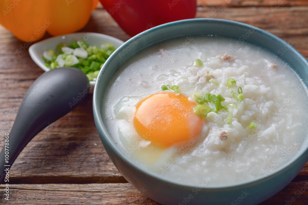 Thai chinese asian rice porridge with pork and egg in bowl, co Thai chinese asian rice porridge with pork and egg in bowl, co